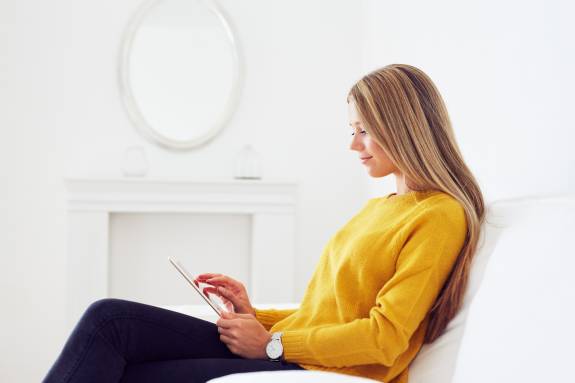 Junge Frau scrollt am iPad