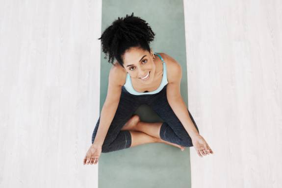Junge Frau lächelt beim Yoga